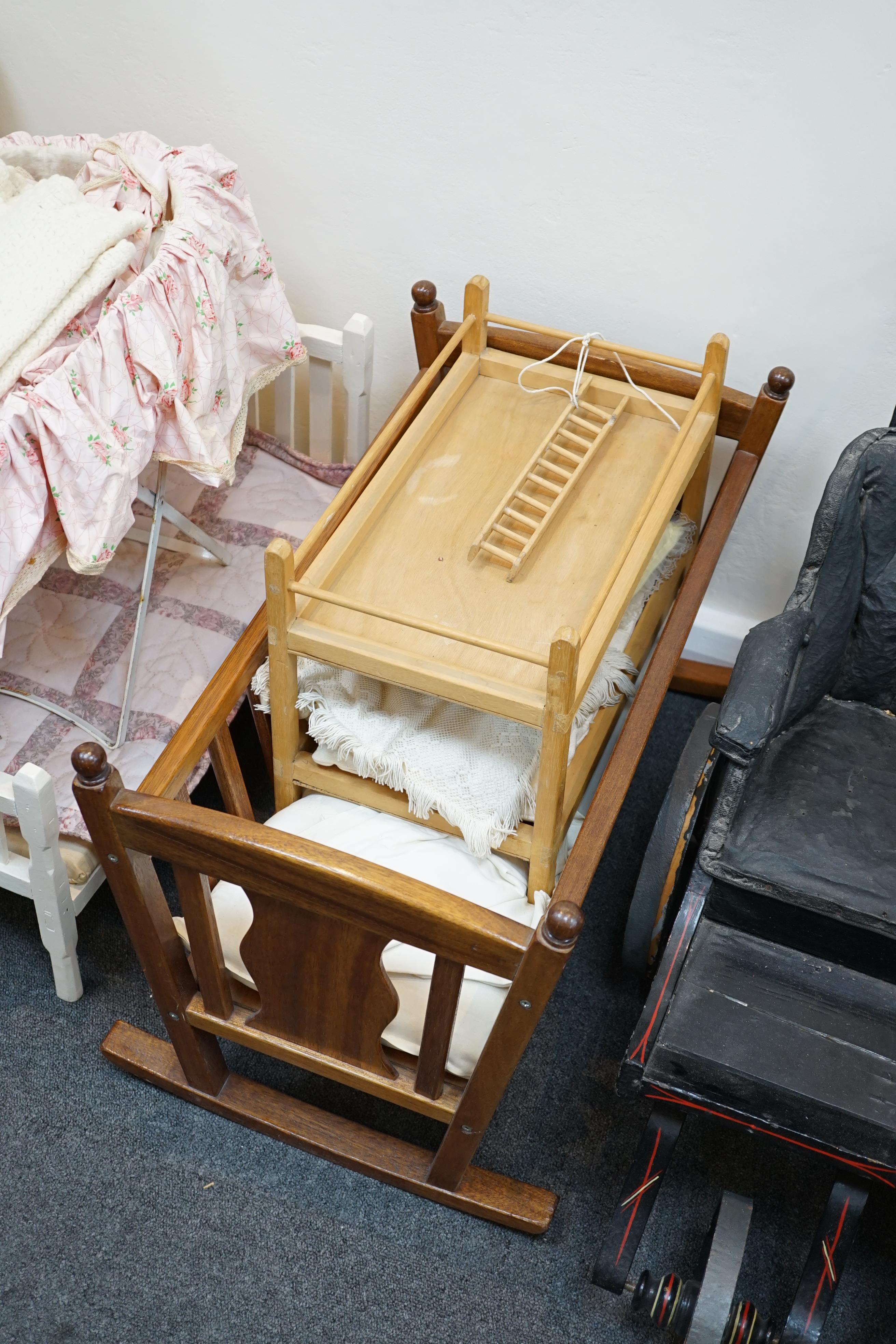 A collection of nine doll’s cribs of wood or wrought iron construction, together with two nineteenth century style doll’s ’bath chairs’, a toy mangle, Disney themed Snow White carpet sweeper and a boxed child’s sewing ma